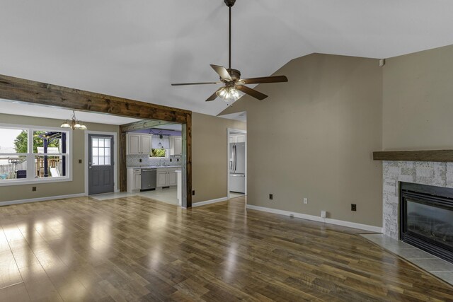 2236 E Logan St, Republic, MO 65738 - unfurnished living room featuring ceiling fan, a fireplace with flush hearth, a chandelier, baseboards, and high vaulted ceiling