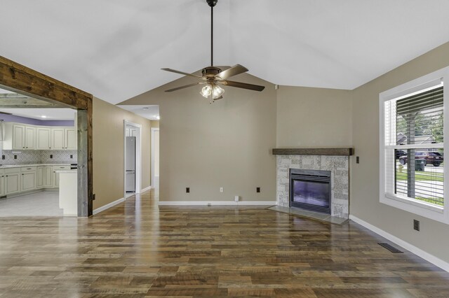 2236 E Logan St, Republic, MO 65738 - unfurnished living room featuring a ceiling fan, vaulted ceiling, a tile fireplace, wood finished floors, and baseboards