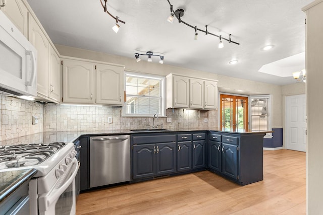 4501 N 16th St, Ozark, MO 65721 - kitchen with white appliances, a peninsula, dark countertops, and white cabinetry