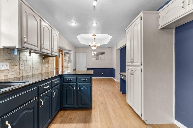4501 N 16th St, Ozark, MO 65721 - kitchen with a peninsula, white cabinets, tasteful backsplash, light wood-type flooring, and blue cabinetry