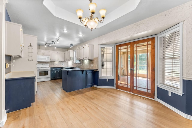 4501 N 16th St, Ozark, MO 65721 - kitchen featuring white appliances, a peninsula, french doors, a chandelier, and backsplash