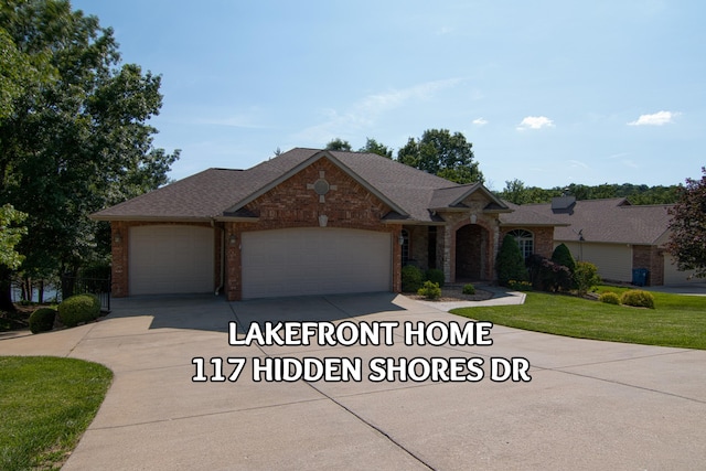 117 Hidden Shores Dr, Branson West, MO 65737 - view of front of home featuring a garage, driveway, brick siding, a front yard, and stone siding