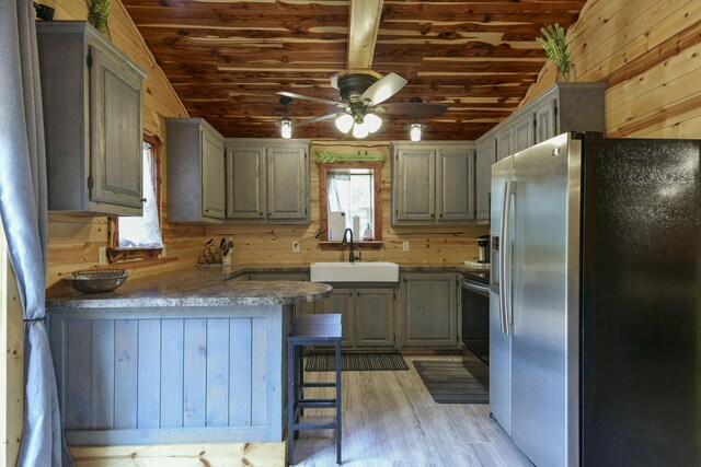 145 Allison Bnd, Lampe, MO 65681 - kitchen with stainless steel fridge, a sink, vaulted ceiling, wood walls, and a peninsula