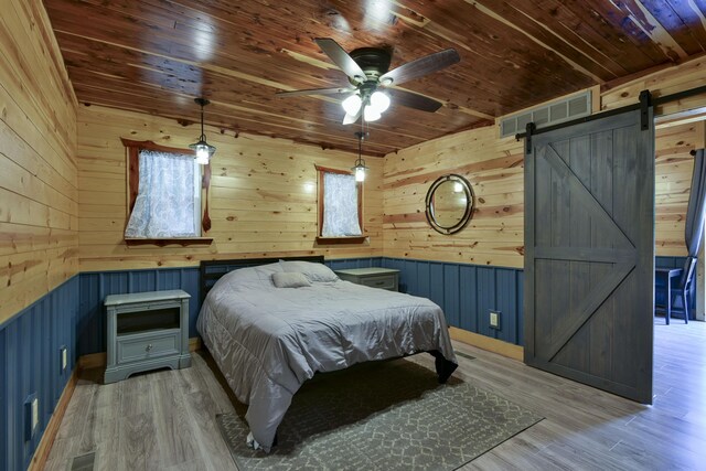 145 Allison Bnd, Lampe, MO 65681 - bedroom featuring a barn door, wooden walls, wooden ceiling, and light wood finished floors
