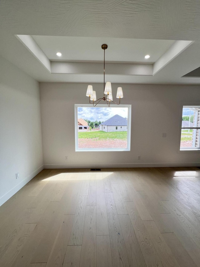 2090 N Silver Charm Ave, Springfield, MO 65802 - empty room with a raised ceiling, wood finished floors, a chandelier, and recessed lighting