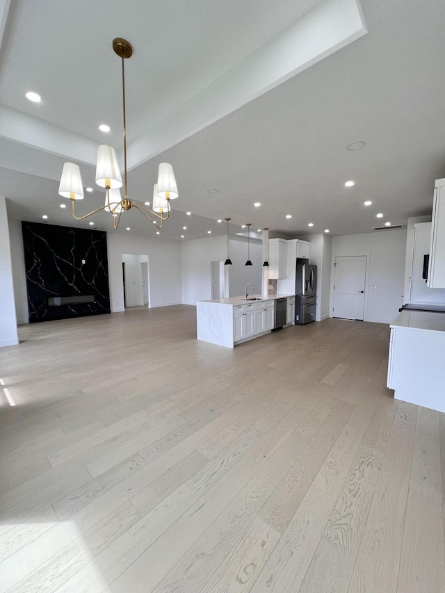 2090 N Silver Charm Ave, Springfield, MO 65802 - unfurnished living room featuring a sink, light wood-style floors, a chandelier, and recessed lighting