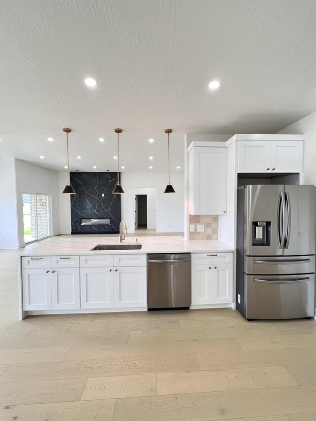 2090 N Silver Charm Ave, Springfield, MO 65802 - kitchen featuring appliances with stainless steel finishes, a sink, white cabinets, decorative backsplash, and recessed lighting