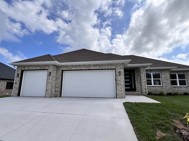 2090 N Silver Charm Ave, Springfield, MO 65802 - prairie-style house featuring a garage, concrete driveway, a front yard, and brick siding