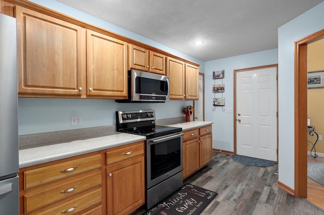 920 Bradford Ct, Marshfield, MO 65706 - kitchen featuring appliances with stainless steel finishes, dark wood-style floors, light countertops, and recessed lighting