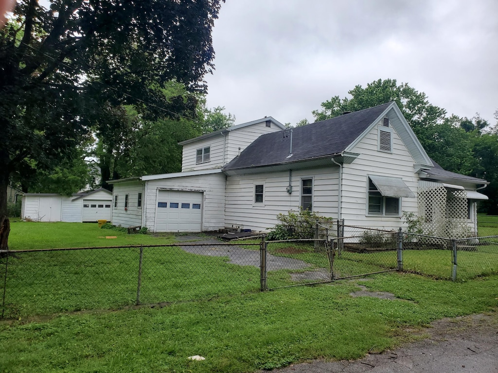 620 S Weaver Ct, Springfield, MO 65806 - view of side of home featuring asphalt driveway, a garage, a shingled roof, a gate, and a shed
