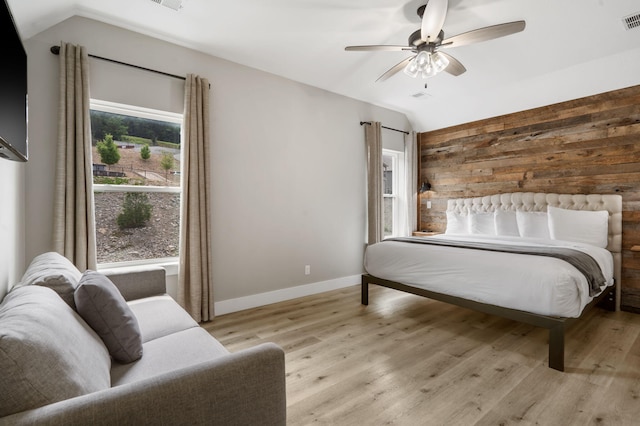 400 Lake Front Dr, Branson, MO 65616 - bedroom with lofted ceiling, light wood-style floors, baseboards, ceiling fan, and wood walls