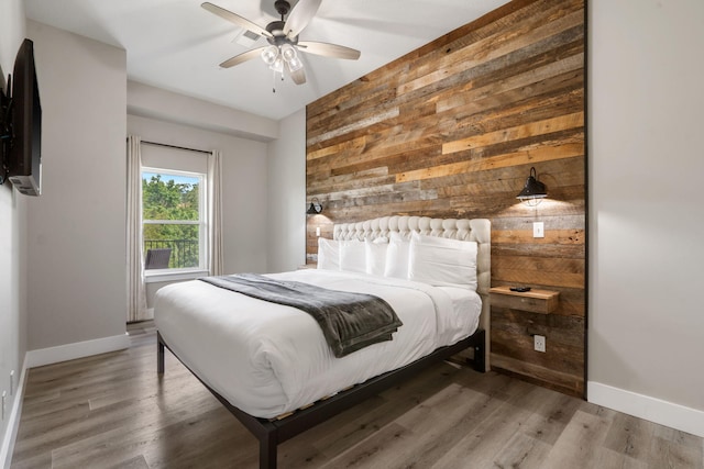400 Lake Front Dr, Branson, MO 65616 - bedroom featuring wood walls, baseboards, wood finished floors, and a ceiling fan