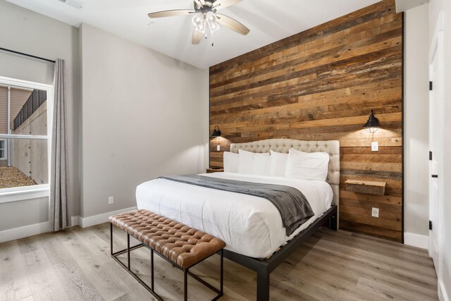 400 Lake Front Dr, Branson, MO 65616 - bedroom featuring wooden walls, light wood-style flooring, baseboards, and a ceiling fan
