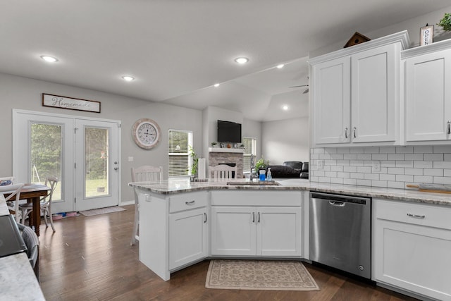 419 Wyldewood Dr, Fordland, MO 65652 - kitchen featuring stainless steel dishwasher, a sink, a fireplace, a peninsula, and white cabinets