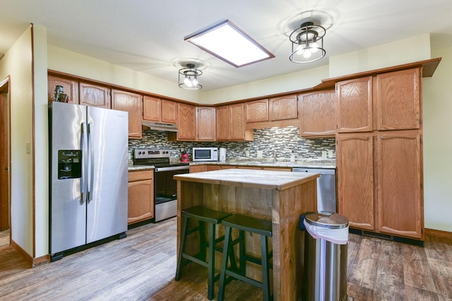 26094 State Highway 39, Shell Knob, MO 65747 - kitchen with stainless steel appliances, under cabinet range hood, light countertops, and wood finished floors