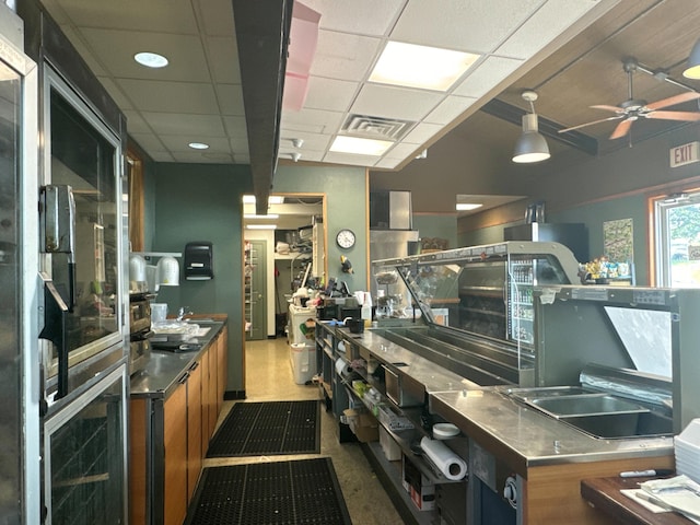 26094 State Highway 39, Shell Knob, MO 65747 - kitchen featuring stainless steel countertops, brown cabinets, a paneled ceiling, a ceiling fan, and a sink
