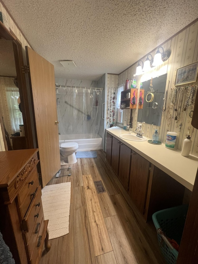 1615 E 562nd Rd, Brighton, MO 65617 - bathroom with wood finished floors, a textured ceiling, toilet, vanity, and enclosed tub / shower combo