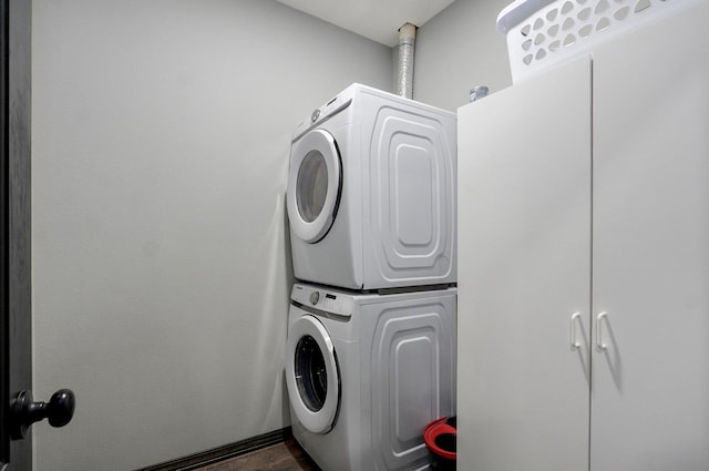 22510 Lawrence Unit 1200, Aurora, MO 65605 - laundry room featuring stacked washer and clothes dryer, cabinet space, and dark wood-style floors