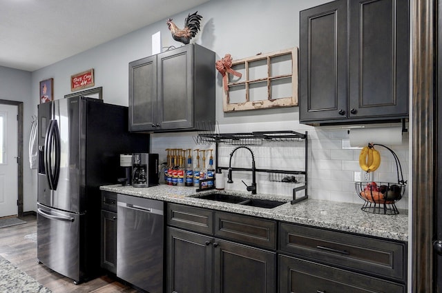 22510 Lawrence Unit 1200, Aurora, MO 65605 - kitchen with stainless steel appliances, a sink, tasteful backsplash, wood finished floors, and light stone countertops
