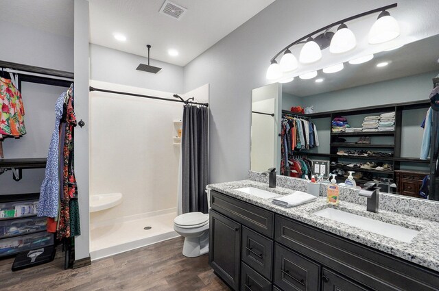 22510 Lawrence Unit 1200, Aurora, MO 65605 - full bathroom featuring wood finished floors, curtained shower, double vanity, toilet, and a walk in closet