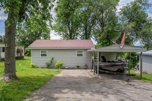 166 Seaman St, Cape Fair, MO 65624 - rear view of house featuring driveway, metal roof, a lawn, and a detached carport