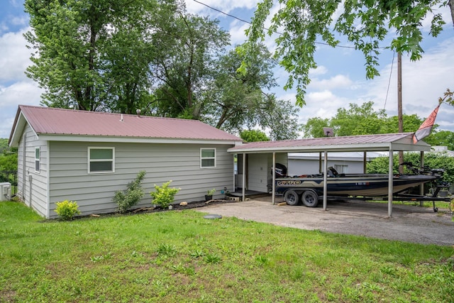 166 Seaman St, Cape Fair, MO 65624 - rear view of house with a lawn, a detached carport, metal roof, cooling unit, and driveway