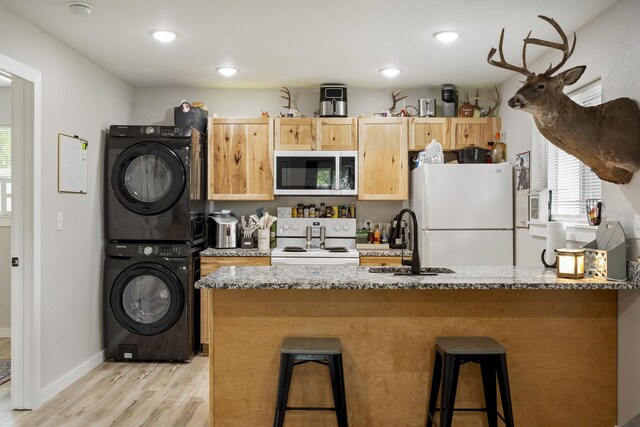166 Seaman St, Cape Fair, MO 65624 - kitchen featuring white appliances, estacked washer and dryer, a sink, light wood-style flooring, and light brown cabinets