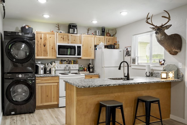 166 Seaman St, Cape Fair, MO 65624 - kitchen with white appliances, stacked washing machine and dryer, a sink, light wood-style floors, and light brown cabinets
