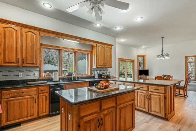 1915 S Farm Rd Unit 219, Springfield, MO 65809 - kitchen with a kitchen island, a sink, brown cabinets, a peninsula, and light wood finished floors