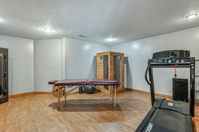1915 S Farm Rd Unit 219, Springfield, MO 65809 - workout area featuring light wood-style flooring, baseboards, and a textured ceiling