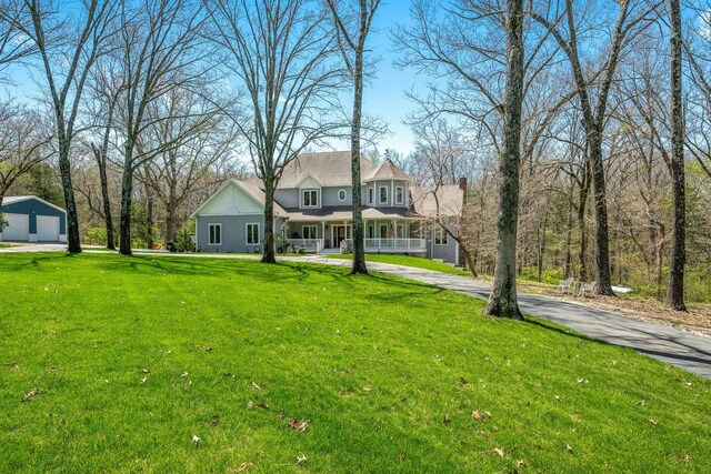 1915 S Farm Rd Unit 219, Springfield, MO 65809 - view of front of property with covered porch, a detached garage, a front yard, and a chimney