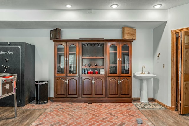 1915 S Farm Rd Unit 219, Springfield, MO 65809 - kitchen featuring brick flooring, glass insert cabinets, baseboards, and recessed lighting