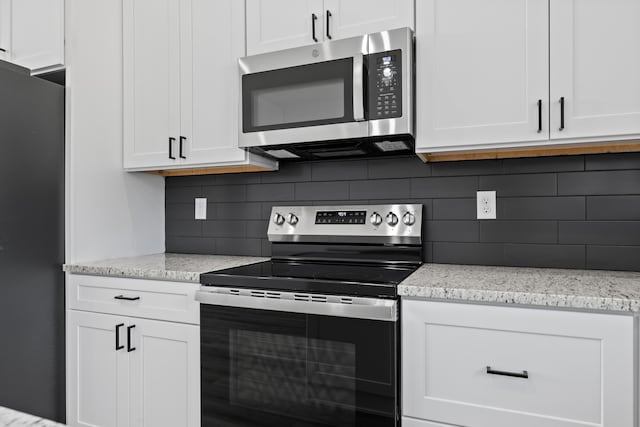 20 Teak Dr Unit 15, Reeds Spring, MO 65737 - kitchen featuring stainless steel appliances, white cabinetry, backsplash, and light stone counters