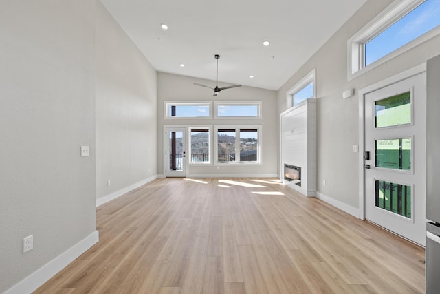 20 Teak Dr Unit 15, Reeds Spring, MO 65737 - unfurnished living room with ceiling fan, a glass covered fireplace, light wood-style flooring, baseboards, and high vaulted ceiling