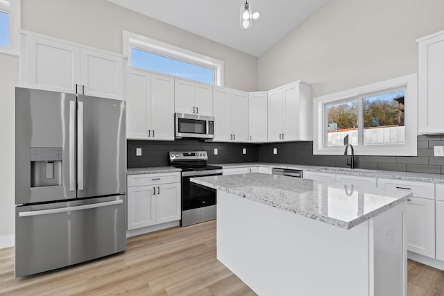 20 Teak Dr Unit 15, Reeds Spring, MO 65737 - kitchen featuring stainless steel appliances, a sink, a center island, decorative backsplash, and white cabinets