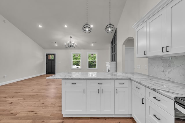 3002 Ginger Dr, West Plains, MO 65775 - kitchen with arched walkways, a peninsula, backsplash, white cabinetry, and light wood-type flooring