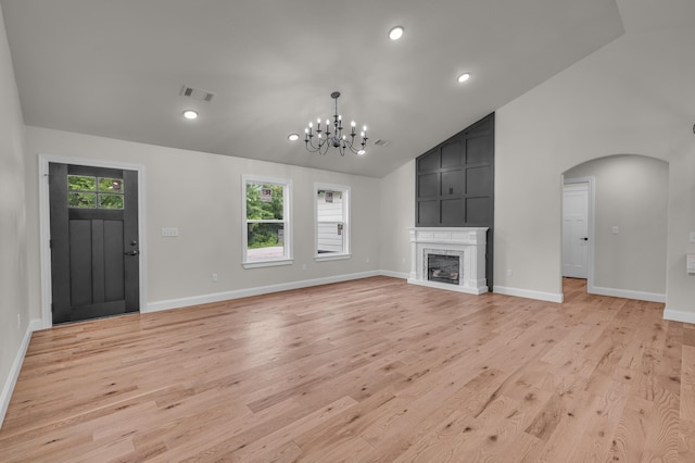 3002 Ginger Dr, West Plains, MO 65775 - unfurnished living room with a chandelier, arched walkways, light wood finished floors, baseboards, and high vaulted ceiling