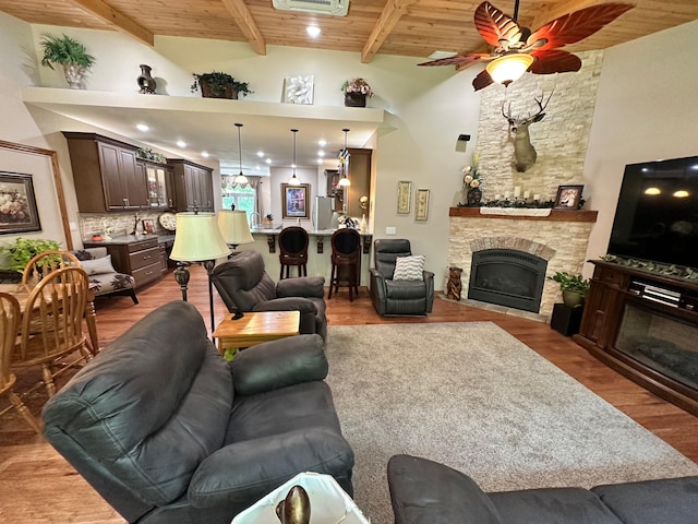 1762 Hickory Ridge Cir, Nixa, MO 65714 - living room featuring a stone fireplace, ceiling fan, wooden ceiling with exposed beams, and wood finished floors
