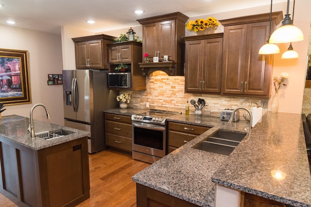 1762 Hickory Ridge Cir, Nixa, MO 65714 - kitchen with appliances with stainless steel finishes, a sink, light wood-style floors, tasteful backsplash, and recessed lighting