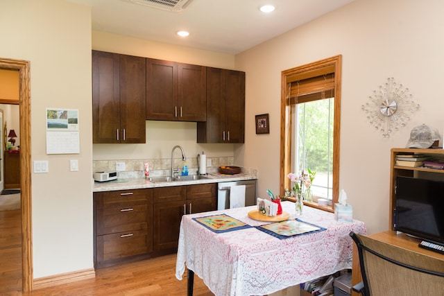 1762 Hickory Ridge Cir, Nixa, MO 65714 - kitchen with a sink, dishwasher, light wood-style flooring, light countertops, and dark brown cabinetry