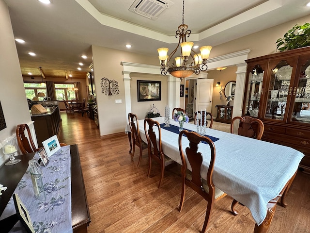 1762 Hickory Ridge Cir, Nixa, MO 65714 - dining space featuring ornate columns, a chandelier, wood finished floors, recessed lighting, and a tray ceiling