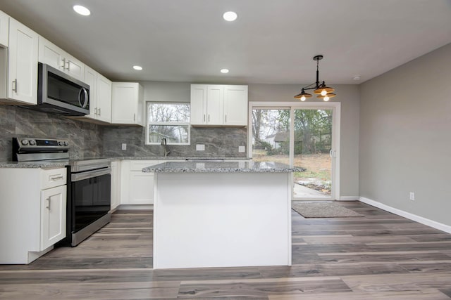 304 Rice St, Nixa, MO 65714 - kitchen with appliances with stainless steel finishes, baseboards, white cabinetry, a center island, and recessed lighting