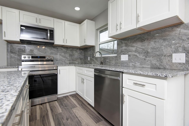 304 Rice St, Nixa, MO 65714 - kitchen with appliances with stainless steel finishes, a sink, white cabinets, dark wood-style flooring, and recessed lighting