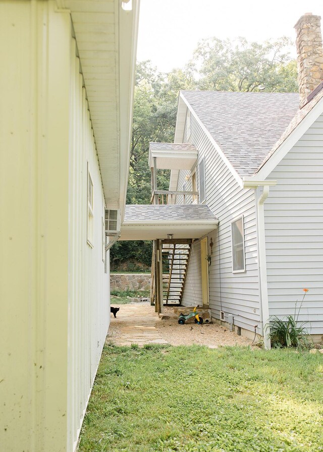 19429 E State Highway 14, Ava, MO 65608 - view of side of home featuring a lawn, a shingled roof, a chimney, and stairs