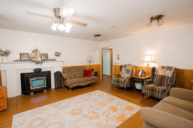 19429 E State Highway 14, Ava, MO 65608 - living area with wainscoting, a fireplace, ceiling fan, and wooden walls