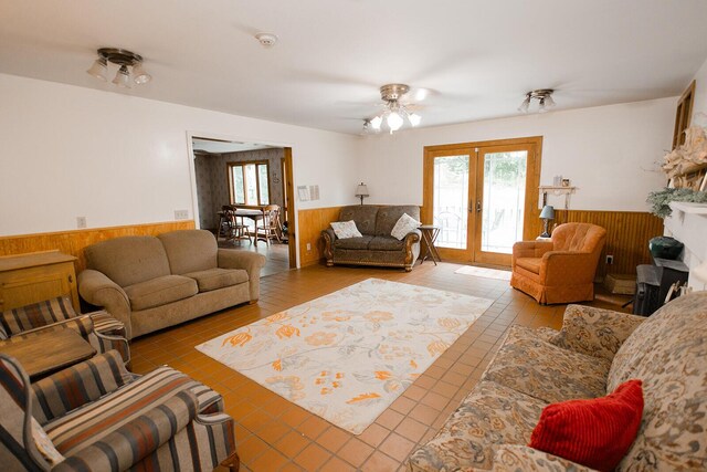 19429 E State Highway 14, Ava, MO 65608 - living area with a wainscoted wall, french doors, tile patterned floors, a ceiling fan, and wood walls