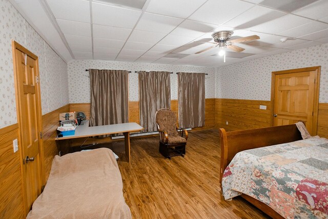 19429 E State Highway 14, Ava, MO 65608 - bedroom with a wainscoted wall, wood finished floors, wallpapered walls, and ceiling fan