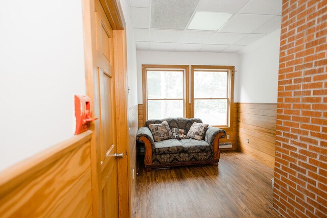 19429 E State Highway 14, Ava, MO 65608 - living room featuring a drop ceiling, a wainscoted wall, wood finished floors, baseboard heating, and wooden walls