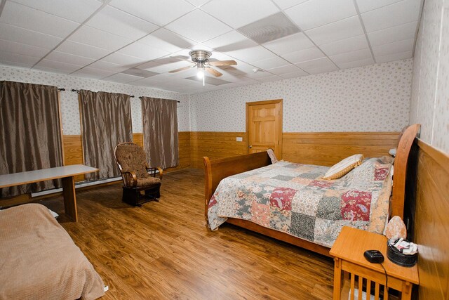 19429 E State Highway 14, Ava, MO 65608 - bedroom with wallpapered walls, a wainscoted wall, a drop ceiling, wood finished floors, and wood walls
