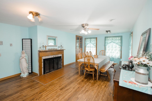 19429 E State Highway 14, Ava, MO 65608 - dining space featuring wood finished floors, a fireplace with flush hearth, a ceiling fan, and baseboards